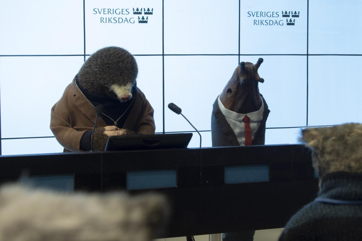 Ein animierter Maulwurf und Schnecke geben eine Pressekonferenz